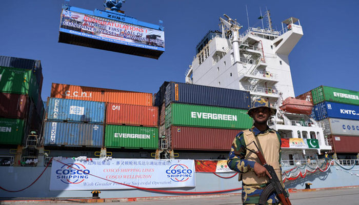 A representational image showing a security personnel sanding guard beside a ship carrying containers at Gwadar port. — AFP/File