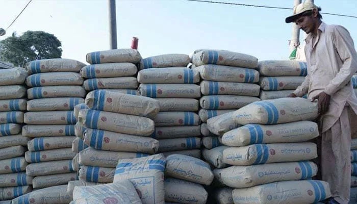 A labour stands alongside a heap of stacked-up cement bags somewhere in Pakistan. — AFP/File