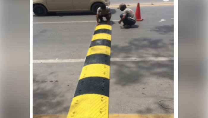 In this image laborer colors on road humps. — MADE-IN-PAKISTAN.COM.PK/File