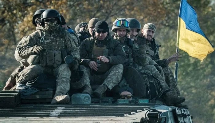 Ukrainian soldiers ride on an armored vehicle in Novostepanivka, Kharkiv region on  September 19, 2022. — AFP