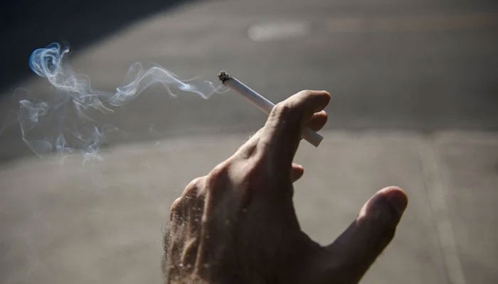 A representational image shows a person holding a cigarette. — AFP/File