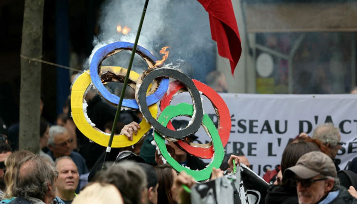 People burn Olympic rings made with cardboard during the yearly protest marking International Labour Day, also known as May Day, in Paris on 1 May, 2024. — AFP