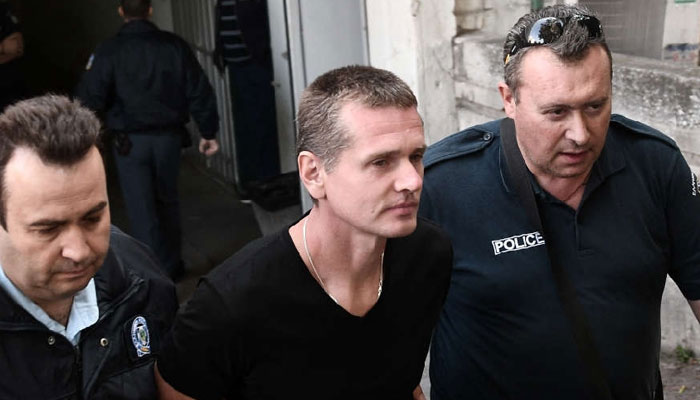 Russian suspected cybercrime kingpin Alexander Vinnik (centre) being escorted by police personnel. — AFP/File