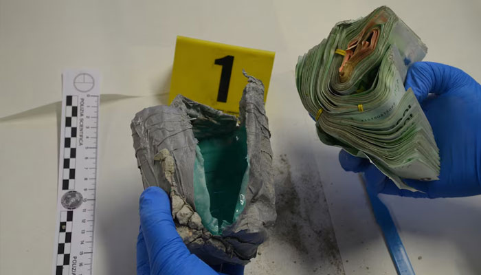 A police officer handles money seized during an operation against Ndrangheta in this photo taken in an unknown location, Italy, September 6, 2019. — Reuters