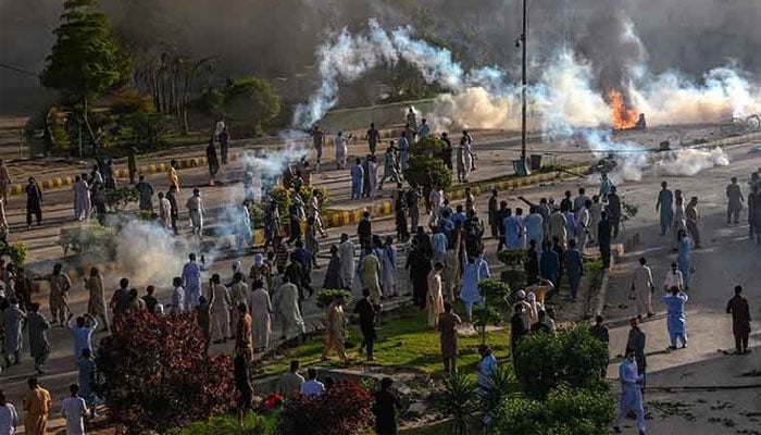 Police fire teargas shell towards Pakistan Tehreek-e-Insaf party activists and supporters of former prime minister Imran Khan to disperse them during a protest against in Peshawar on May 9, 2023. — AFP