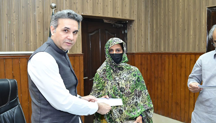 Divisional Superintendent Railway Lahore M Hanif Gul distributes an insurance cheque to the widow of the railway employee who lost their life while on duty at the DS office on May 14, 2024. — Facebook/Pakistan Railways Lahore Division