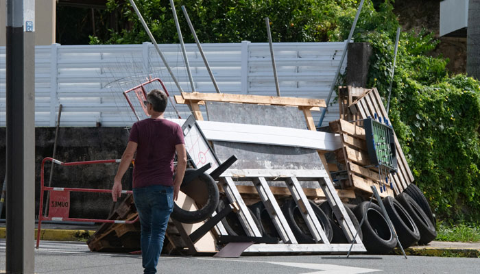 A man walks past a roadblock barricade, set up by residents, in the Motor Pool district in Noumea on May 16, 2024.— AFP/file