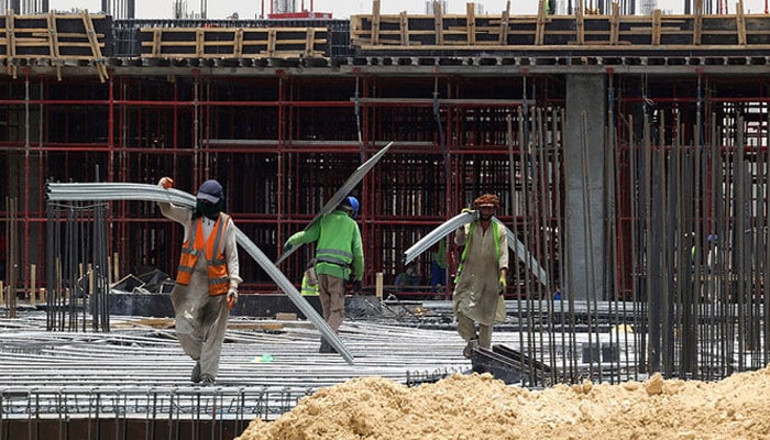 Labourers work at a construction site. — AFP/File