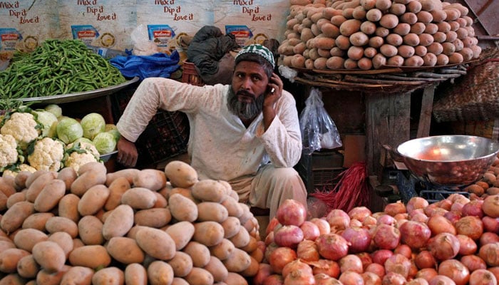 A man selling vegetables waits for customers at his makeshift stall at Empress Market in Karachi. —  Reuters/File