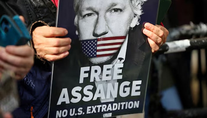 A Julian Assange supporter holds a sign. London, Britain, March 26, 2024. — Reuters