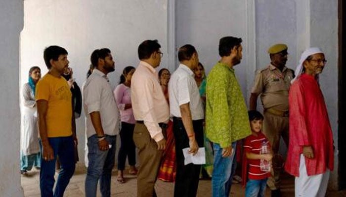 People stand in a queue to cast their ballot to vote at a polling booth during the fifth phase of voting of India’s general election in Ayodhya, in the countrys Uttar Pradesh state. — AFP/File