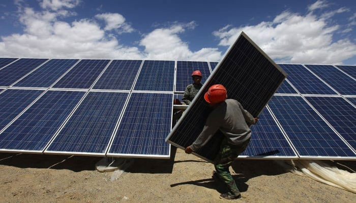 This image shows workers installing a solar panel. — Reuters/File