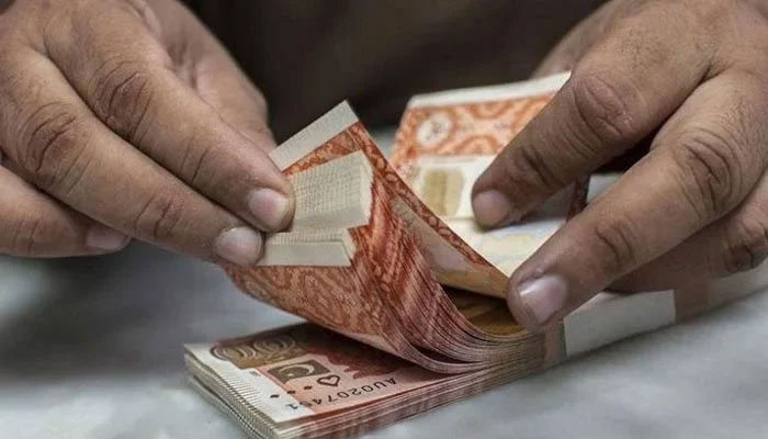 A representational image showing a man counting Rs5,000 rupee notes. — AFP/File
