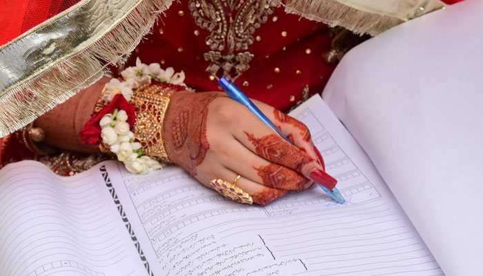 A representational image showing a bride signing Nikah papers. — X/@iris_petal_dew/File