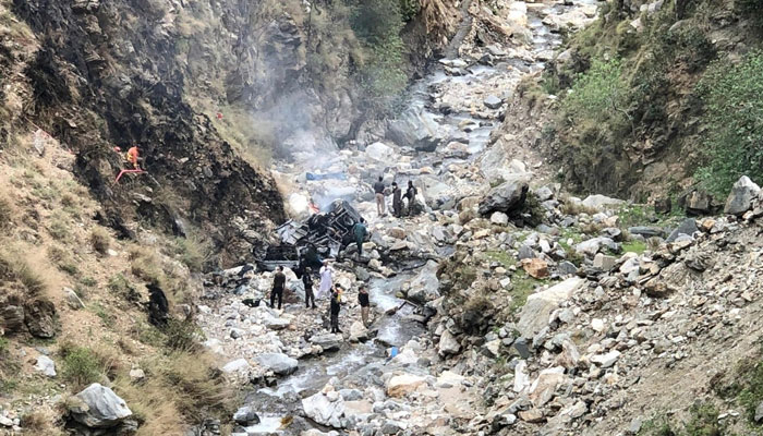 Security officials inspect the wreckage of a vehicle carrying Chinese nationals that plunged into a deep ravine after a suicide attack near Besham city in Shangla, KP. — AFP/File