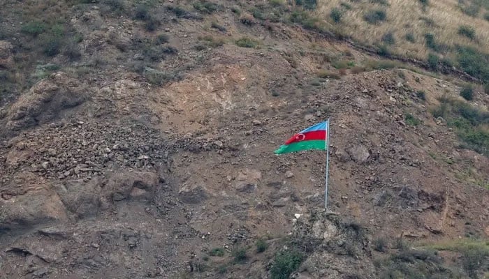 This photograph taken from the Armenian side of the border near the town of Kornidzor, on September 23, 2023, shows an Azerbaijan flag on the Azerbaijan side of the border near the Lachin corridor. — AFP