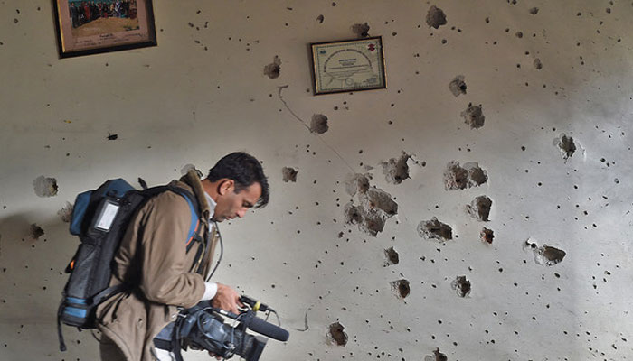 A representational image of a camera documenting a bullet-riddled wall at the site of a terrorist attack. — AFP/File