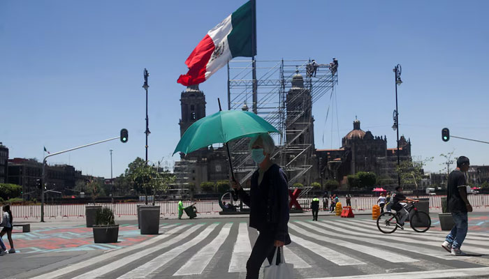 A woman holds an umbrella during a period of high temperatures in Mexico City. — Reuters/File