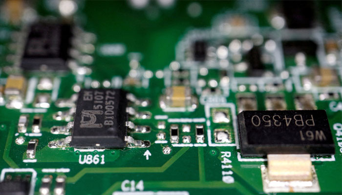 Semiconductor chips are seen on a printed circuit board in this illustration picture taken February 17, 2023. — Reuters