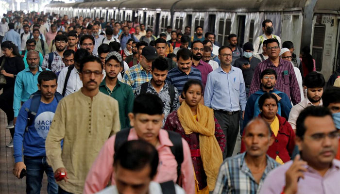 Commuters walk on a platform after disembarking from a suburban train at a railway station in Mumbai, India on January 21, 2023. — Reuters