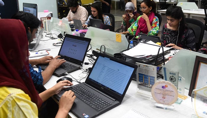 A representational image showing people work at their stations at the National Incubation Centre (NIC) in Lahore. — AFP/File
