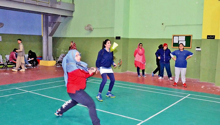 Two female players playing badminton.— The News/file