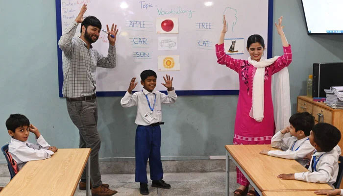 This photograph taken on May 6, 2024 shows teachers leading a class of hearing-impaired students at a school in Lahore. — AFP