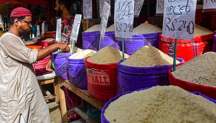 A customer buys rice at a wholesale shop in Karachi. — AFP/File