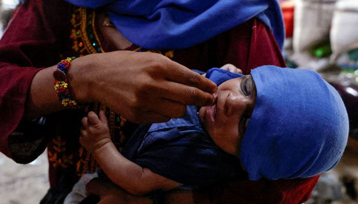 A mother uses her fingers to give water drops to her child during a hot summer day as a heatwave continues, in Jacobabad, Pakistan May 24. — Reuters