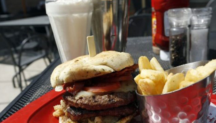 A representational image showing a burger, french fries and a milkshake at a restaurant. — Reuters/File