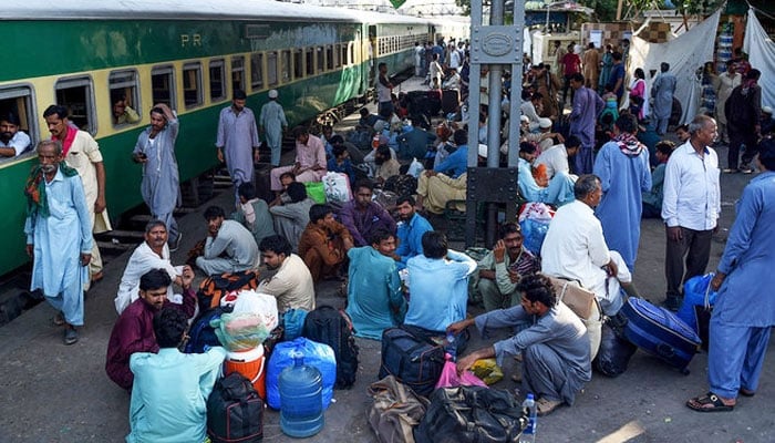 Passengers wait for the train at a railway station in Karachi on June 2, 2019. — AFP