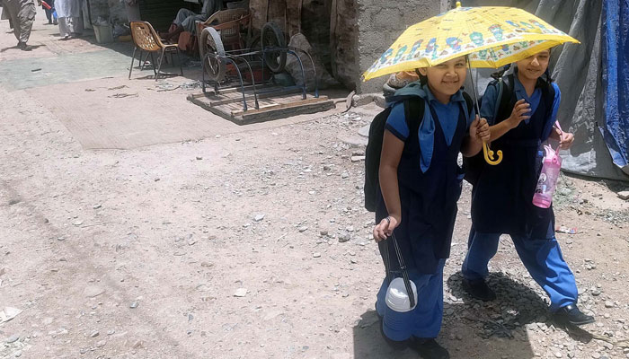 School children carry umbrella to protect themselves from scorching sun during a hot weather in Karachi on  May 29, 2024. — PPI