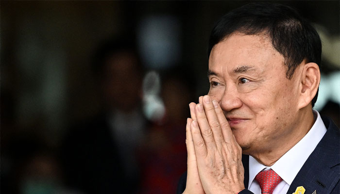 Former Thai Prime Minister Thaksin Shinawatra greets his supporters after landing at Bangkok’s Don Mueang airport on August 22, 2023. — AFP