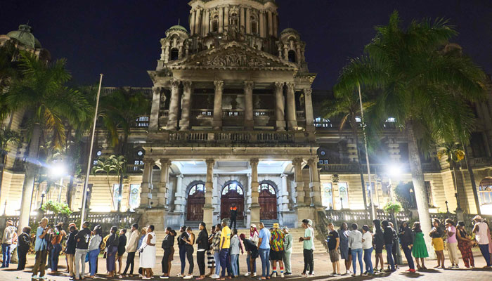 Voters wait in line at night outside the city hall voting station in Durban on May 29, 2024. — AFP