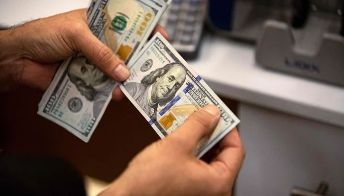 A representational image of a  currency exchange agent counting US dollars  — AFP/File