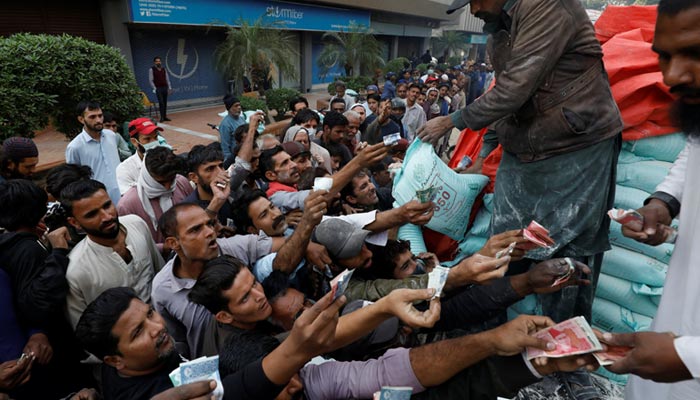 Men reach out to buy subsidised flour sacks from a truck in Karachi, January 10, 2023. — Reuters