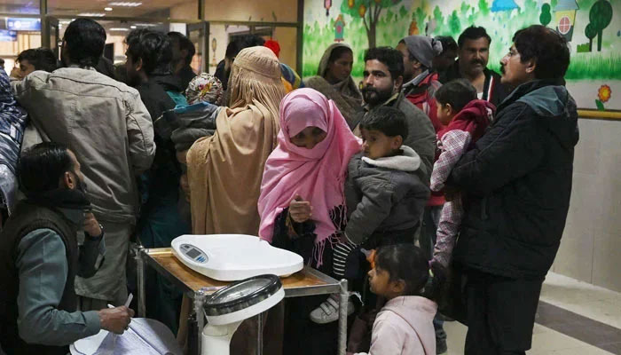 Parents wait with their child suffering from pneumonia in Hospital on January 31, 2024. — AFP