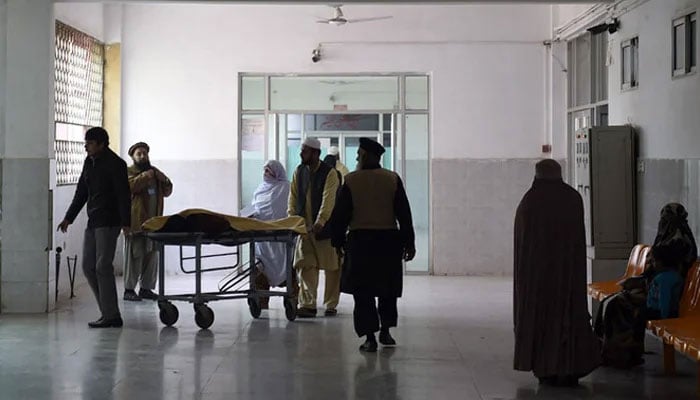 A representational image of a patient along with his relatives at a hospital in Peshawar. —AFP/File