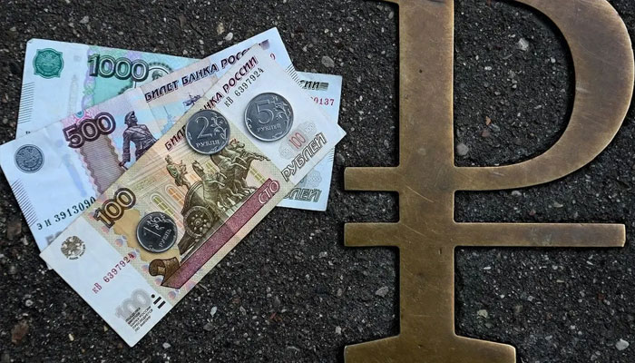 This picture taken on August 13, 2021, in Moscow, shows Russian ruble coins and banknotes pictured next to Russian ruble sign. — AFP