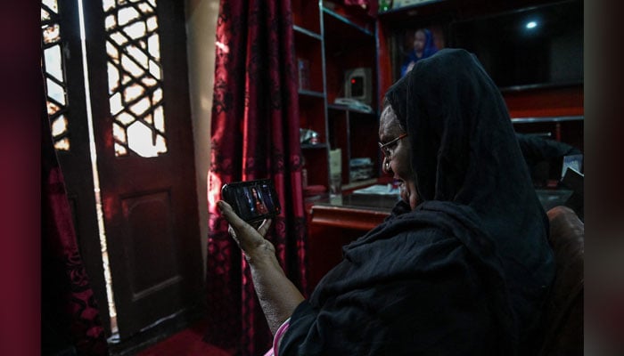 This photograph taken on May 16, 2024, shows a woman watching the trailer of a Netflix series on mobile mobile phone in Lahore. — AFP