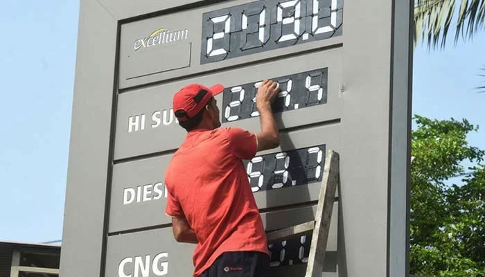 A representational image of a petrol station staffer updating fuel prices in Karachi. — AFP/File