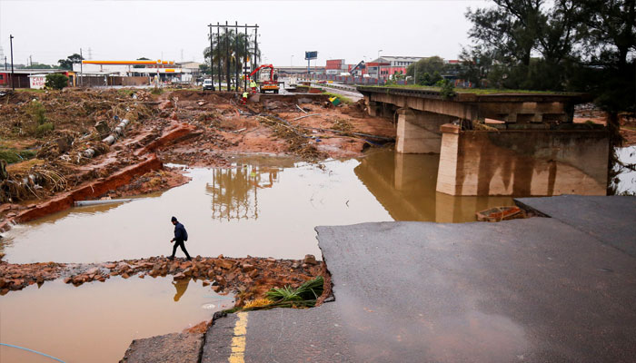 A man walks around a damaged bridge caused by flooding in Umlazi near Durban, South Africa, April 16, 2022. — Reuters