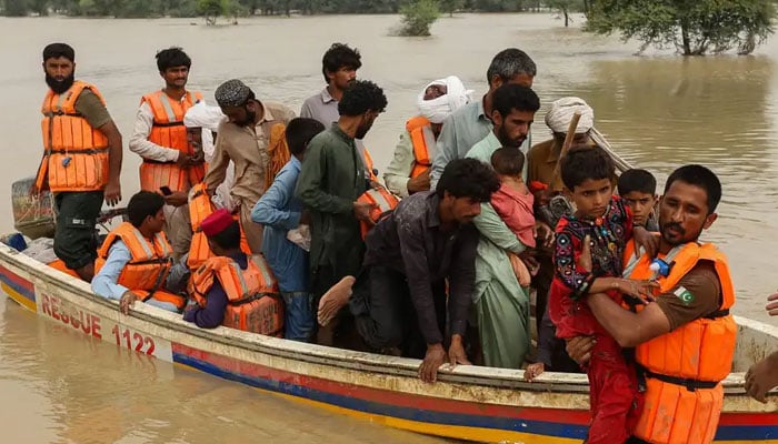 Rescue workers help to evacuate flood-affected people from their flood-hit homes following heavy monsoon rains in Rajanpur district of Punjab. — AFP/File