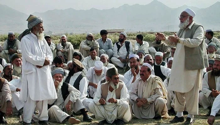 A representational image shows people sitting while an elder speaks. — AFP/File