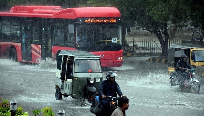 Commuters struggle to move forward in a flooded street after heavy monsoon rain in Karachi on July 05.— Online