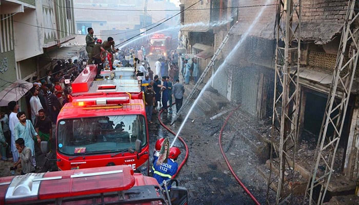 Firefighters struggling to extinguish the fire at LPG gas shop after cylinder explosion in Hyderabads Paretabad area. — APP