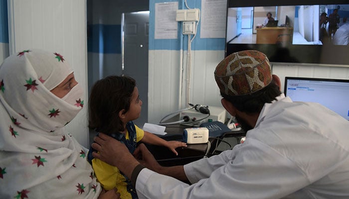 This representational image shows a Pakistani paramedic checking a child at a telemedicine online treatment centre in Pakistan. — AFP/File