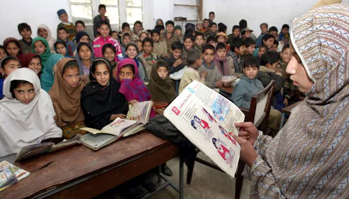 A student reads a book in front of her classmates in a school at Chilliana village in Azad Jammu and Kashmir (AJK). — Reuters/File