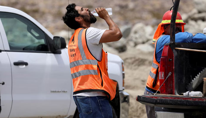 A contruction worker drinks water in temperatures that have reached well above triple digits in Palm Springs, California, US on July 20, 2022. — Reuters