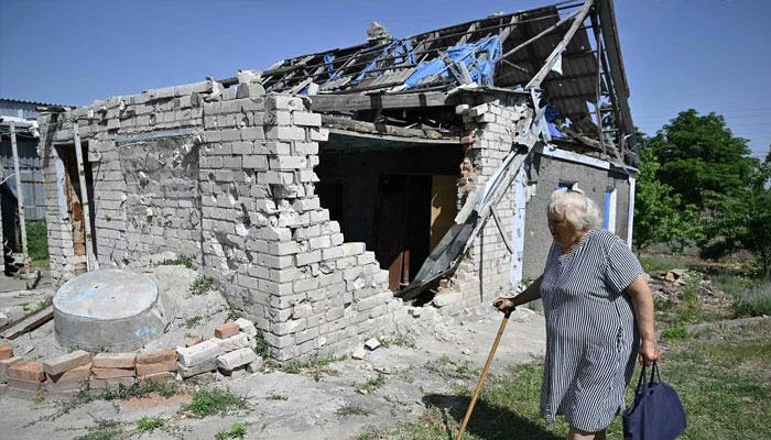 A woman walking past her house damaged amid Russias invasion of Ukraine in Ukraines Kherson region, on June 3. — AFP/File